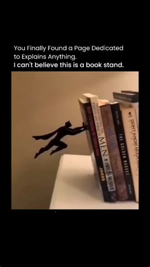 Explains Anything on Instagram: "This post showcases a viral video of a metal bookend sculpted as a caped superhero clinging to a stack of books, creating an illusion of preventing them from falling, which has earned over 10,000 likes for its clever and whimsical design. . . The product, similar to Amazon's Artori Design Bookends, blends functionality with humor, as replies include direct purchase links and comments praising its detailed, lifelike appearance that encourages impulse buys for unre
