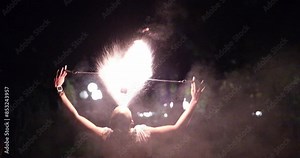 female fire dancer twirl burning baton creating sparkling trails in motion dark outdoors, twirler. Fire show woman Vietnam Ho Chi Minh City