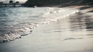Beautiful landscape, a wave runs on the sandy shore of the sea, close-up. High quality 4k footage