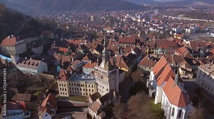 Birds eye view over Sighisoara city. Aerial footage of medieval city of Sighisoara from Romania, taken from a drone at higher altitude with the Clock Tower in the front.