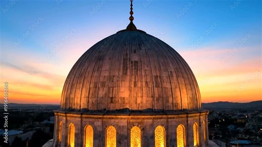 Large illuminated dome of a historic building at dusk with smaller domes and blue sky