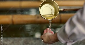 Temple, closeup and person washing hands in water, container and clean with faith for wellness. Religion, mindfulness and Shinto purification ritual to stop evil, bacteria or peace at shrine in Tokyo