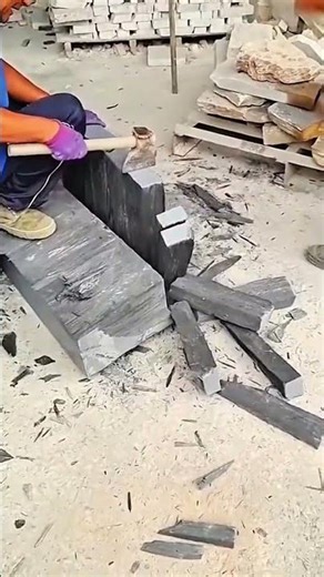 Hammer and chisel split stone clean—purple gloves guide rhythm of traditional masonry strength.