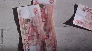 Horizontal video. Russian cash money falls on wooden table. Paper banknote. 5000 rubles. Concept of financial crisis in Russia, currency exchange, tax, trip, loan, debt, credit, rich, bribery, budget