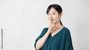 口に指を当てる若い女性 ライフスタイルイメージ