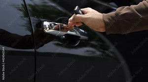 Close up male hand holding car key. Man unlock car door by remote key push button near door and open getting in car.