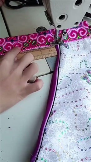 sewing on a piece of cloth using a sewing machine in a designated area#sewing