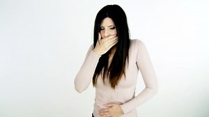 Sick woman with stomach ache throwing up