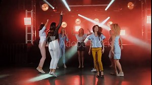 Happy women dancing to the music of party with her other girl friends on the dance floor of a fashionable night club in Slow Motion.
