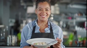 Restaurant Kitchen: Portrait of Black Female Chef Prepares Dish, Tasting Food, Enjoying it. Professional Cook Eats Delicious, Authentic, traditional Food using only Healthy Ingredients for Meal Recipe