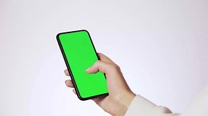Woman holding a smart phone with one hand and scrolling on a green screen. Shopping concept. User experience. Using an app. Vertical scroll, horizontal scroll, tap, zoom in.