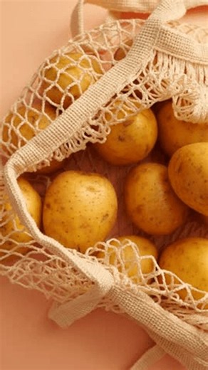 clip-4032420225-several-yellow-potatoes-gathered-inside-woven-net