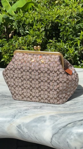 Sealed with a kiss(lock). The coveted Coach Kisslock Frame Bag reimagines archival style as a spacious carryall, featuring a crystal-embellished signature jacquard silhouette. Step inside Coach, located on the Lower Level at Aventura Mall. | Aventura Mall