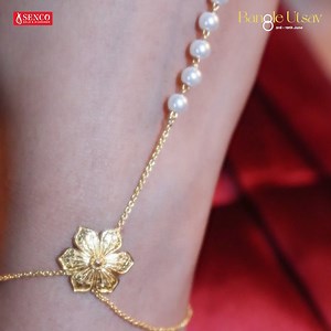 129K views · 993 reactions | Get absolute in-your-face-flair with this ultra-chic, delicate hand bracelet, adorned with a line of pearls. Explore the Bangle collection at https://sencogoldanddiamonds.com or visit at our nearest store of Senco Gold & Diamonds. #Bangles #BangleUtsav #CraftsmanshipForYou #KarigariForYoungIndia #SencoGoldAndDiamonds https://sencogoldanddiamonds.com/products/sole-floral-pearly-gold-haathphool | Senco Gold & Diamonds | Facebook