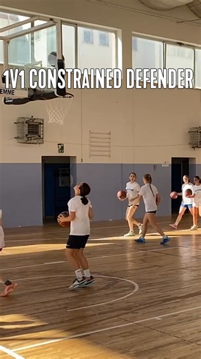 1-on-1 Constrained Defender instructions: 1. Offense dribbles on the perimeter. They can use a skate dribble to move. 2. Defense is guarding while holding a basketball. Must start an arms distance away. 3. Live when offense breaks the 3-point line. 4. Offense is trying to score while defense tries to be stop them. | Transforming Basketball