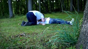 Zombie woman eating dead man in the woods