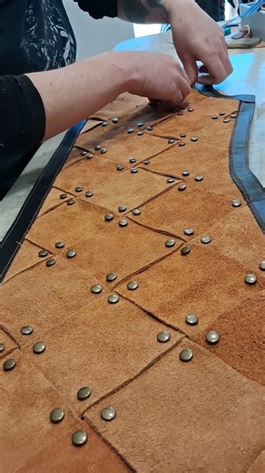 tunique cloutée avec tissage de cuir en cours