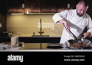 Man in an apron in kitchen is preparing homemade lunch. cook puts cooked noodles with vegetables on plate with tongs. Cooked for gourmets. Prepare food to eat. Culinary gastronomy. Delicious dinner Stock Video Footage - Alamy