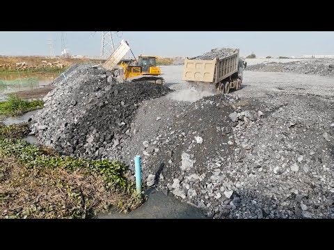 Attention! Operate bulldozer, wheel loader to push rock and dump truck unload rock into giant lake