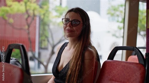 Smiling woman sitting in city bus watching view from window, modern urban commute and lifestyle travel scene