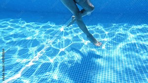 Feet underwater in pool. Underwater view of swimming feet in pool