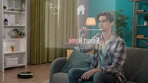 Man sitting on the sofa and using visible virtual reality touch screen for smart house gadgets, clicking on the icon opening curtains. Smart house concept.