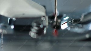 Sewing needle in slow motion. Sewing machine needle work process. Sewing needle working. Sewing machine slow motion. Manufacturing equipment. Process of working of the electric sewing machine.