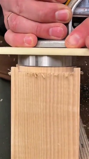 using a handheld router tool to carefully cut precise tenon joints on the edges of wooden boards