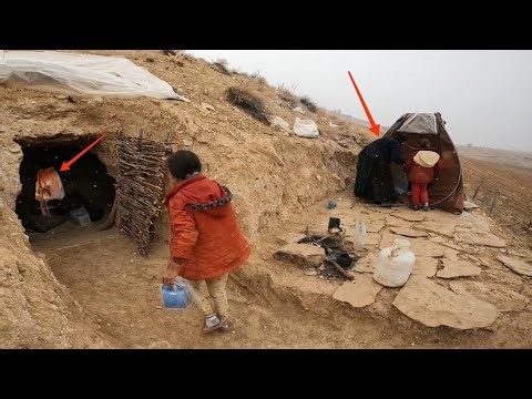 Building a fireplace in the cave before the snow storm by the grandmother and two orphans