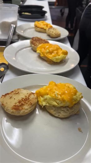 Buttermilk biscuit sandwiches with tomato jam & hash browns getting prepped on the line. Choose bacon or sausage on top. #biscuitsandwich #eggsandwich #clintonstbakingco | Clinton Street Baking Company