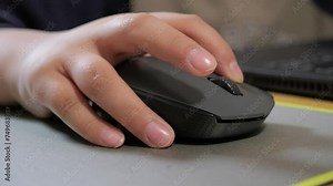 Child holds the computer mouse,child learns and plays on the computer