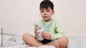 siblings boys brothers playing with stethoscope in doctor pediatrician. smiling happy kid with ear tips in ears.child using bell, chest piece to listen the breathing.baby with soft toy as patient.4k