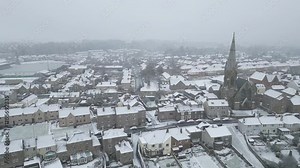 Aerial footage of the snow-covered Kelso town on a cloudy day in Scotland, UK