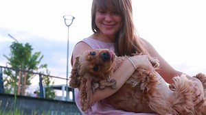 Young woman kissing her dog