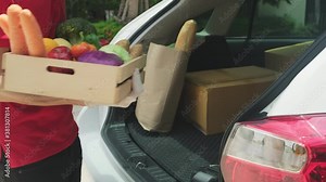 Asian delivery man handling box of foods, groceries, fruits to deliver
