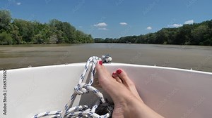 Woman legs and feet relaxing on a boat for tanning while sailing around