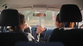 A female driving school instructor is teaching how to drive to a...