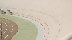 Track cycling teams training on velodrome. Professional cyclists riding on high speed on cycling track