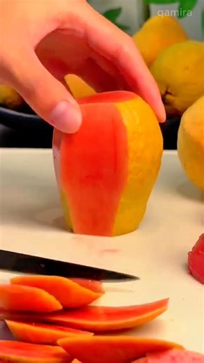 slicing mango into thin pieces with knife and arranging slices neatly on board