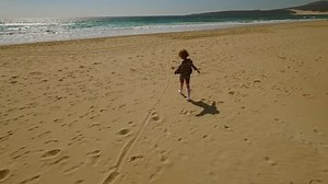 Young woman walking alone along a beach