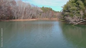 gorgeous aerial footage of the rippling waters of the Catawba River surrounded by lush green trees and autumn colored trees in Charlotte North Carolina USA