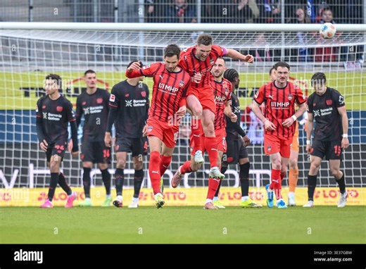 Heidenheim, Germany. 21st Mar, 2026. Soccer, Men: Bundesliga, 1. FC Heidenheim - Bayer Leverkusen, Matchday 27, Voith-Arena. Goalscorer Marvin Pieringer (l, 1. FC Heidenheim 1846) and Patrick Mainka (1. FC Heidenheim 1846) celebrate after the goal to make it 3:3. Credit: Harry Langer/dpa - IMPORTANT NOTE: In accordance with the regulations of the DFL German Football League and the DFB German Football Association, it is prohibited to utilize or have utilized photographs taken in the stadium and/o