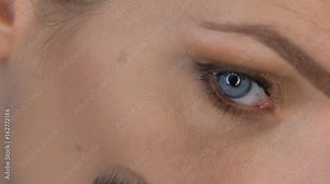 Woman's face applying makeup / Closeup of woman's face applying loose powder under eye with beauty blender sponge - video in slow motion