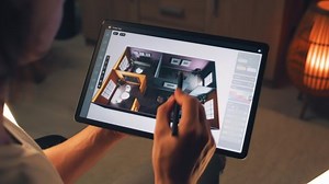 Male 3D designer using digital tablet computer and pencil and creating interior of house in professional design application while working on project remotely