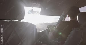 Young adult male driving Camper van on road trip at sunset