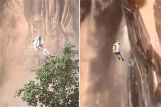 Climber coolly rappels down cliff next to raging muddy waterfall after ‘once-in-150-years’ storm, dramatic video shows