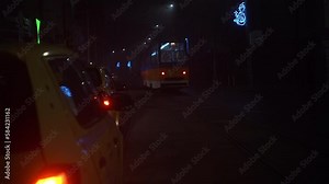 Night time view of metro driving away with taxi cabs in foreground