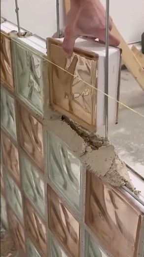 carefully installing glass block cement mortar to build an aesthetic and translucent decorative wall