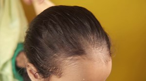 Girl having her hair brushed
