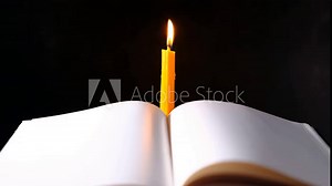 Yellow candlestick gives light while reading, black background
